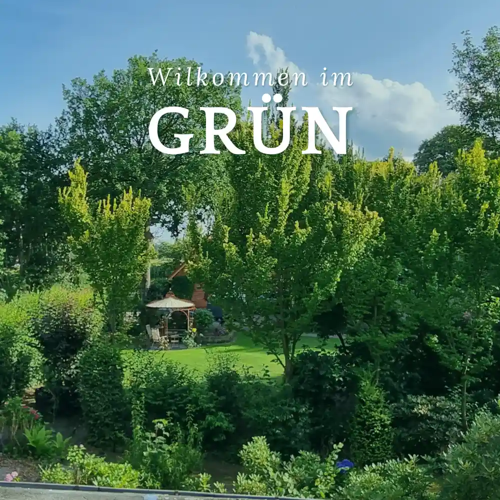 Ferienwohnung Ammerland: Blick in den &uuml;ppigen gr&uuml;nen Garten mit Pavillon und dem Schriftzug &bdquo;Willkommen im GR&Uuml;N&ldquo;.