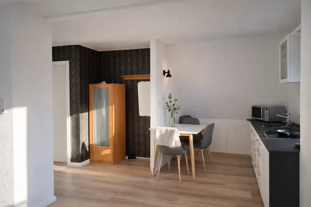 Ferienwohnung nahe Zwischenahner Meer: Moderner Essbereich und K&uuml;che mit Design-Tapete f&uuml;r Ihren Urlaub.