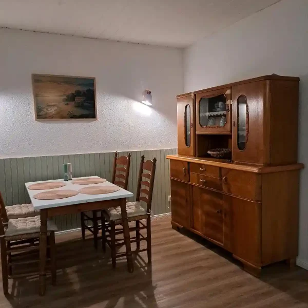 Ferienwohnung Rastede: Historischer Küchenschrank aus Massivholz im rustikalen Essbereich der Unterkunft.