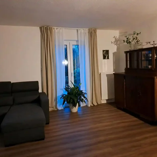 Wohnzimmer Rastede: Einrichtungsmix aus moderner Couch und antiker Vitrine im großzügigen Erdgeschoss.